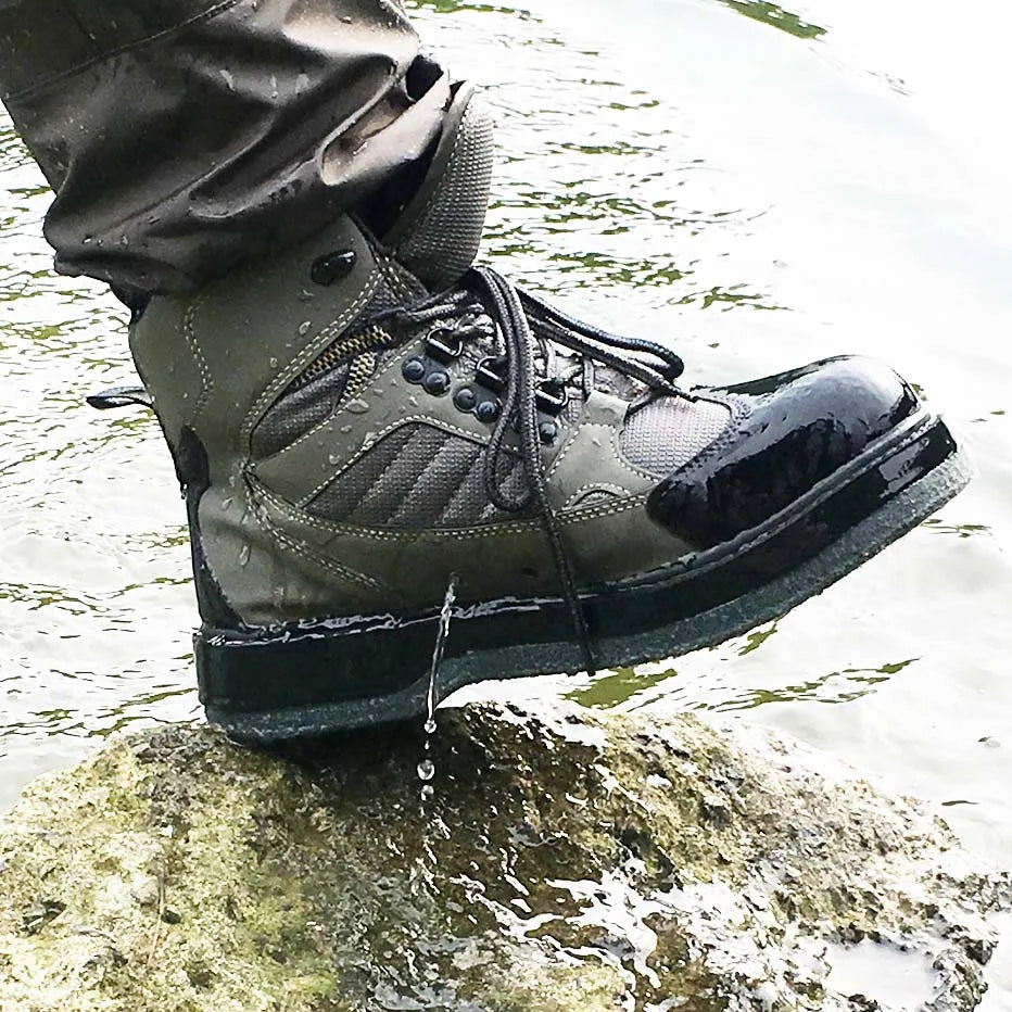 Foot wearing a green boot with a black sole standing on a rock in water