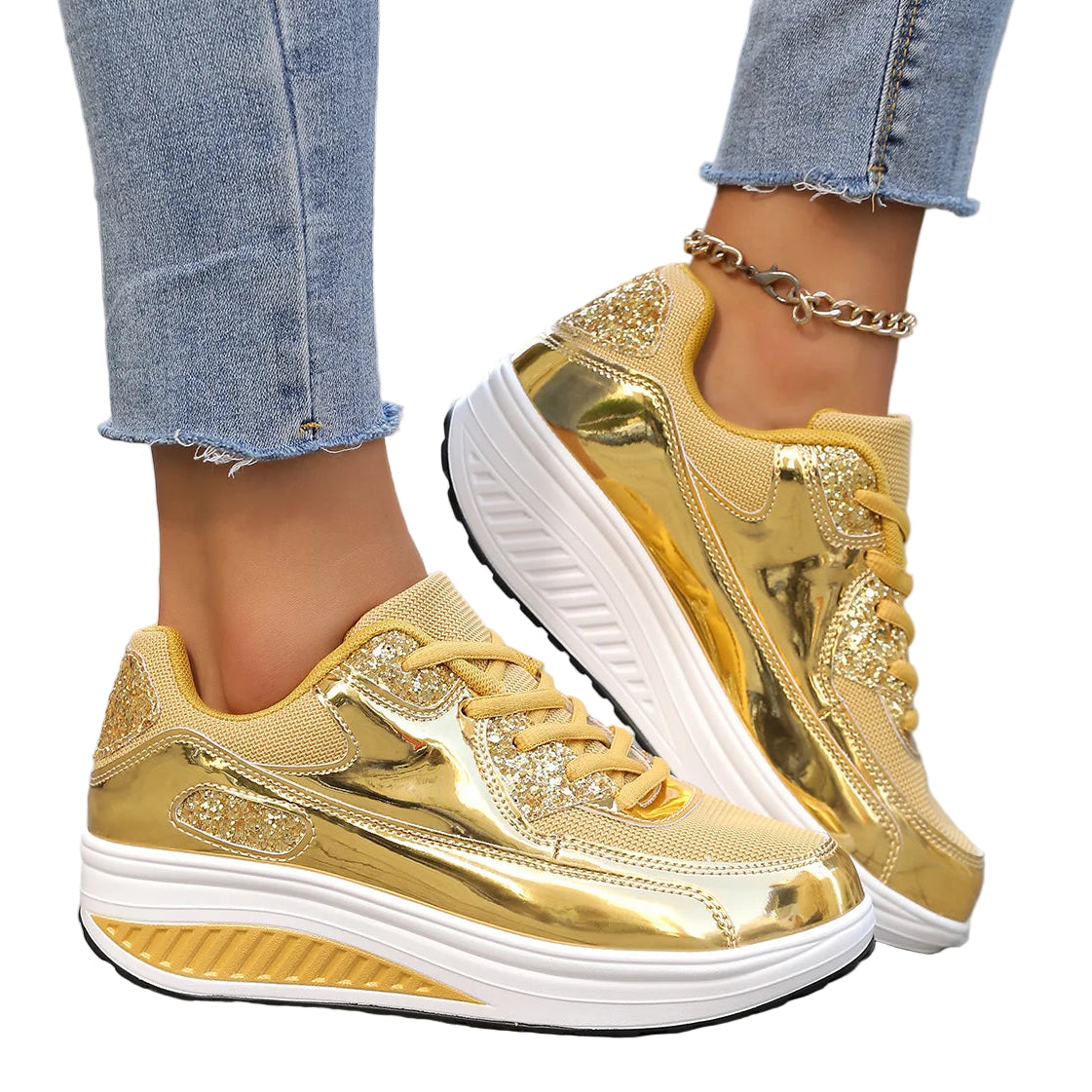 Gold sneakers with white soles worn by a person on a sidewalk.

