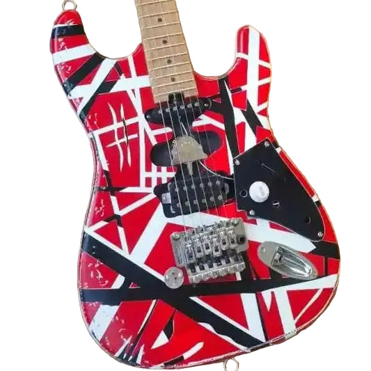 Guitar with red, black, and white design on a cardboard surface