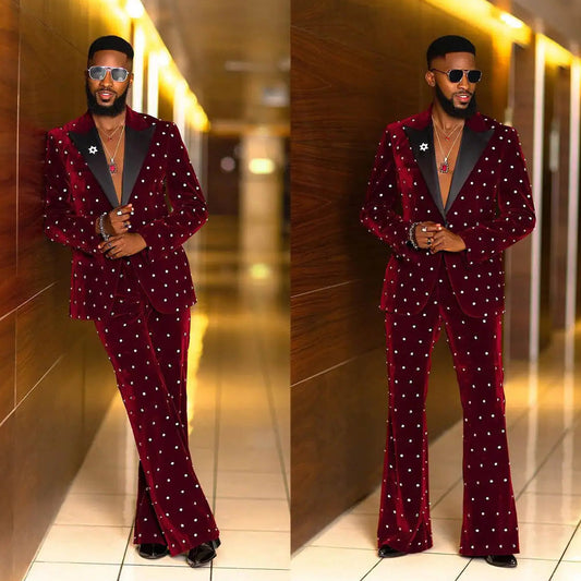 Man wearing a red velvet suit with white embellishments in an indoor setting.