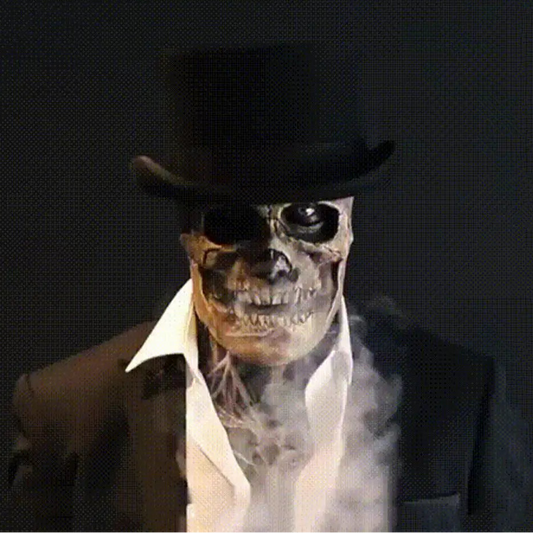 Person wearing a skeleton mask, sunglasses, and a top hat against a dark background