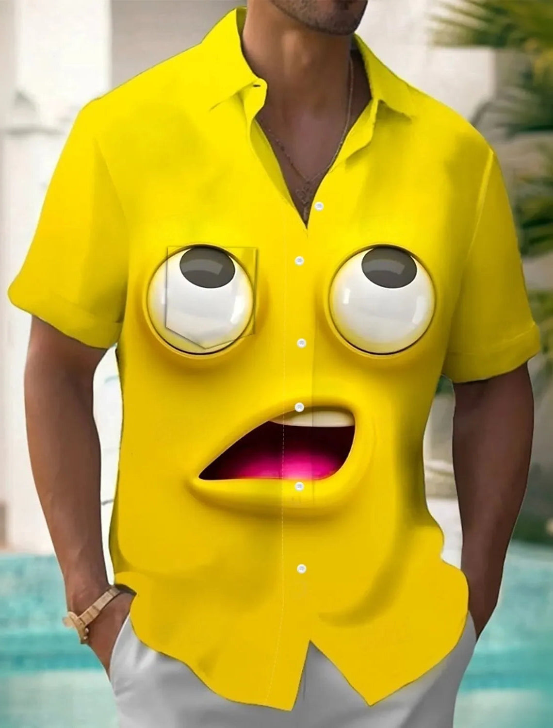 Person wearing a yellow shirt with cartoonish face design outdoors