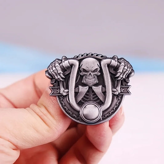 Silver belt buckle with skull design held by a hand against a gradient background