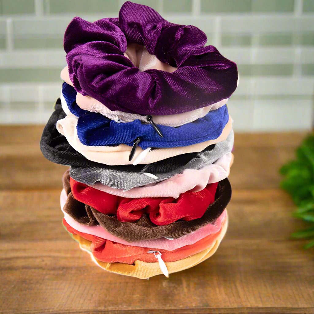 Stack of colorful scrunchies on a white surface with a blurred floral background