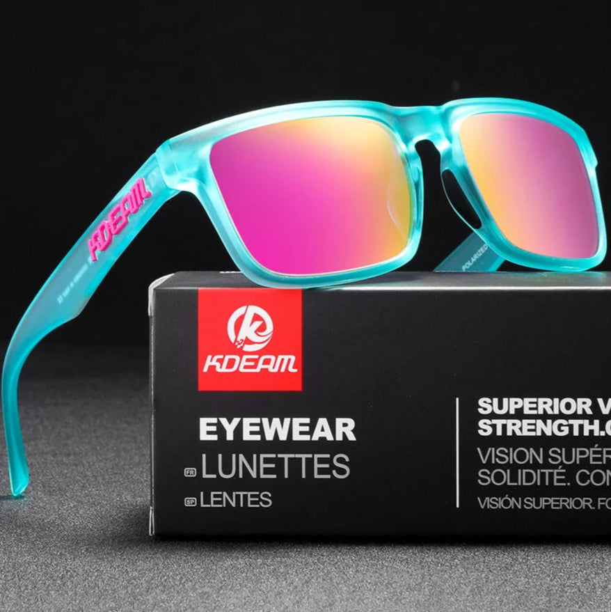 Turquoise sunglasses with pink lenses on a KDEAM eyewear box against a black background
